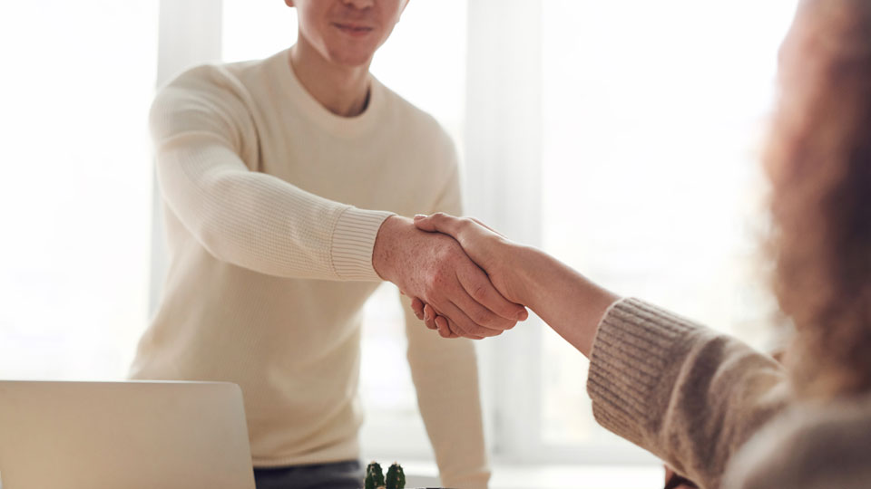 Zwei Personen schütteln sich die Hand