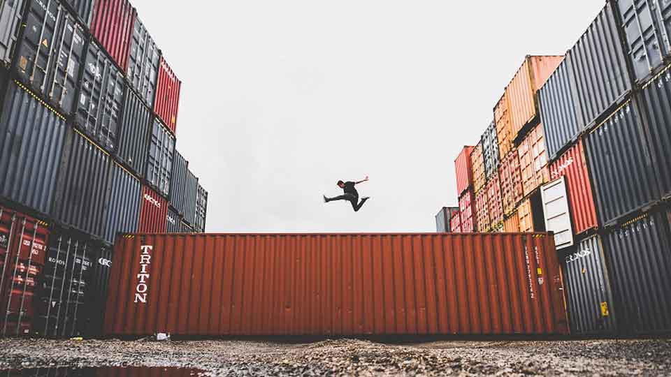 Person springt über Schiffscontainer