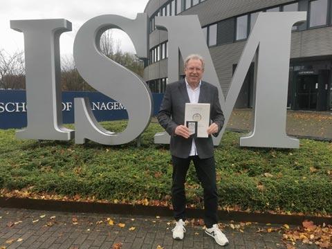 Hochschulpräsident Ingo Böckenholt mit dem Award